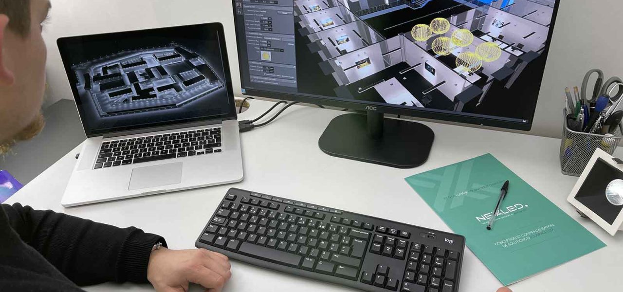 bureau d'étude d'éclairement d'éclairage led dialux evo logiciel 3D homme de dos en train de travailler face bureau avec deux écrans d'ordinateur une souris